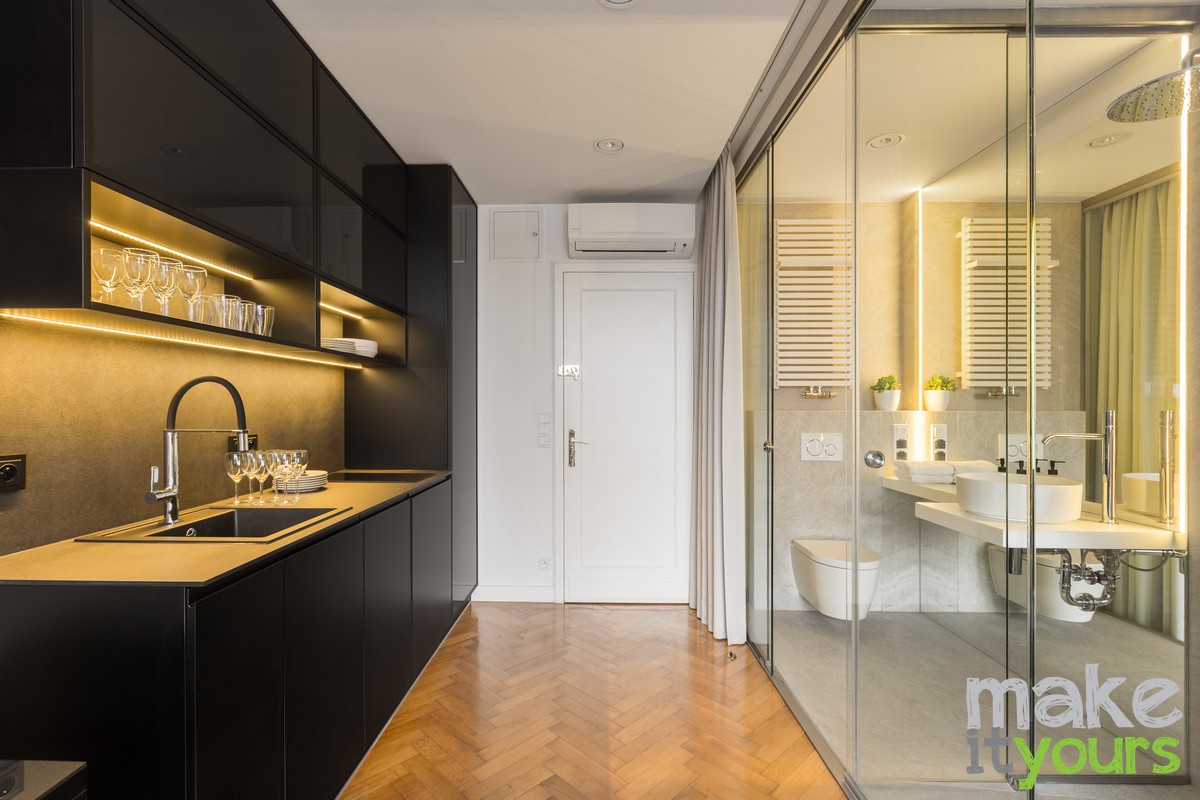 Zdjęcie przedstawia apartament w którym znajduje się przeszklona łazienka w sypialni. Projekt wnętrz od biura Make It Yours z Krakowa