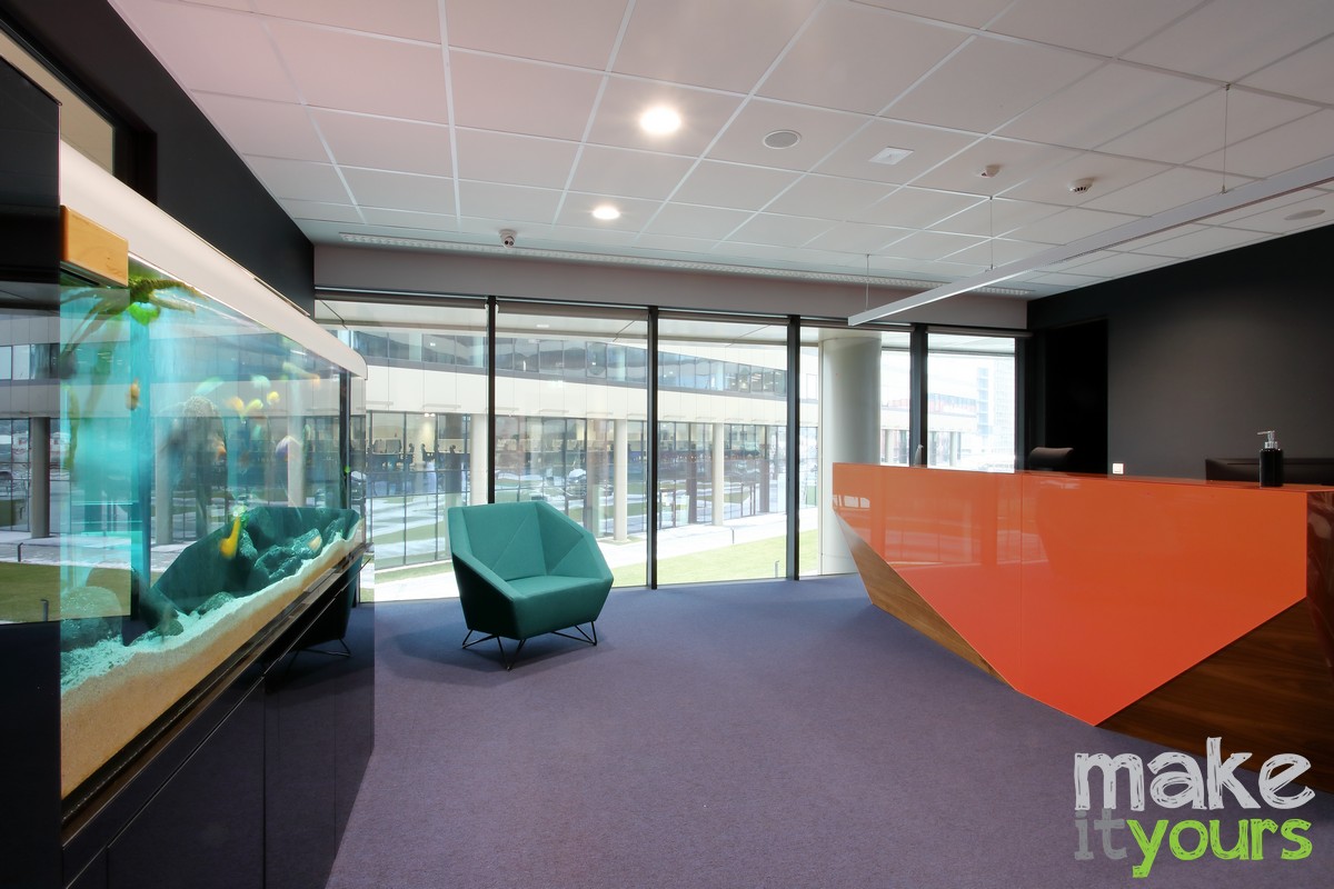 Zdjęcie wnętrz biura ANT, Recepcja w kolorach firmowych - pomarańczowy i niebieski.. Projekt autorstwa Make It Yours - studio projektowania wnętrz.